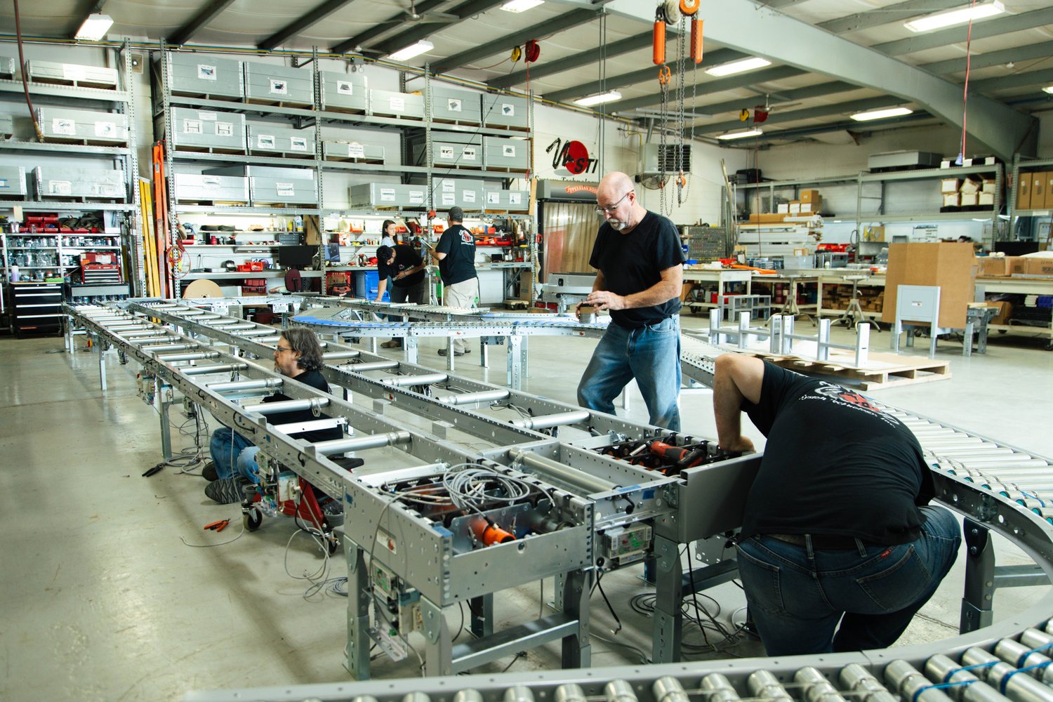 System Technology technicians assembling a roller conveyor line in the shop