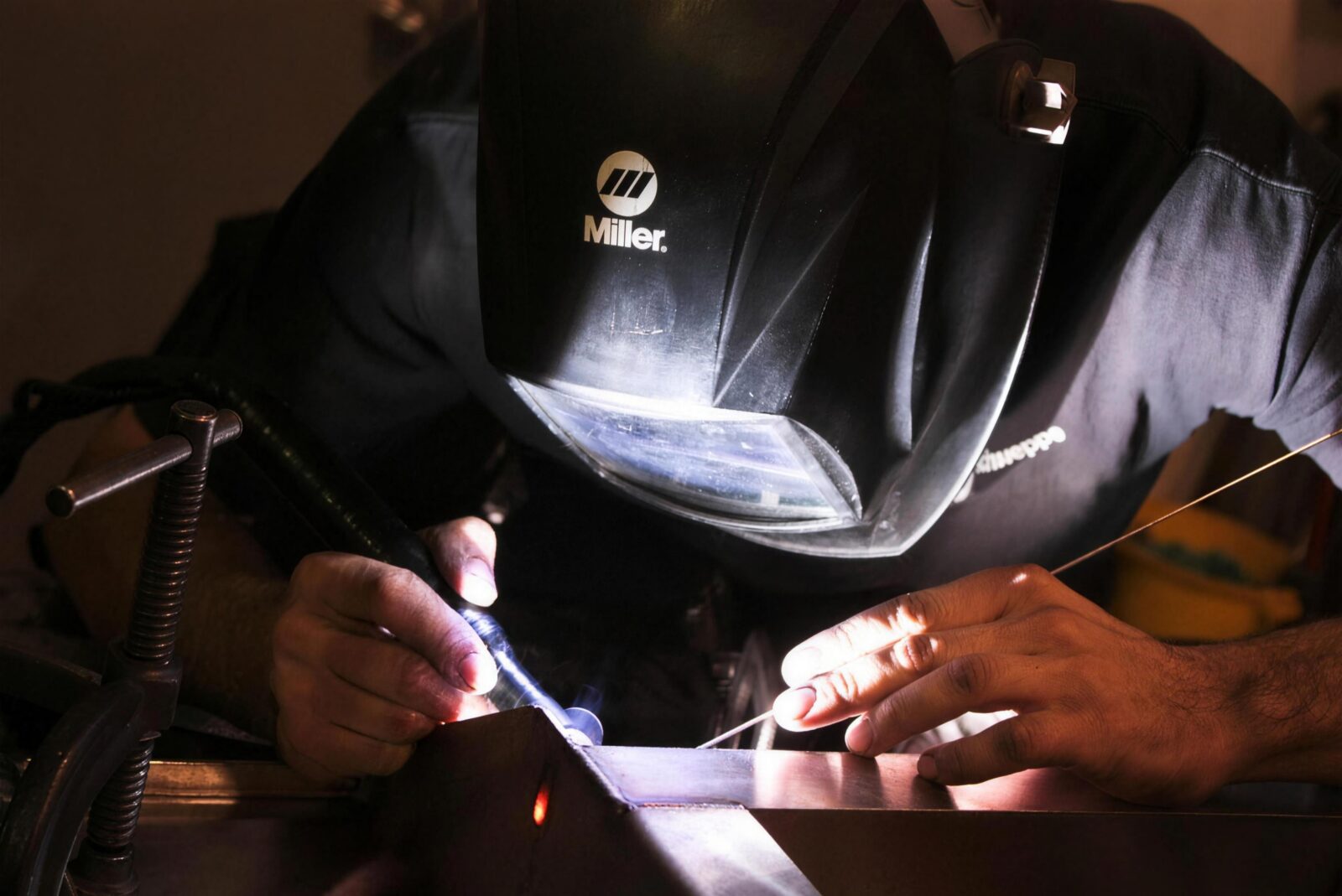 A welder TIG-welding a stainless part in the STI fabrication shop