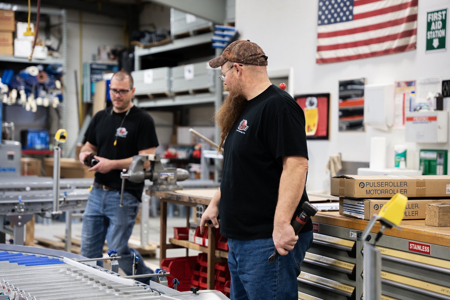 Two System Technology team members at a conveyor line on the Joliet shop floor