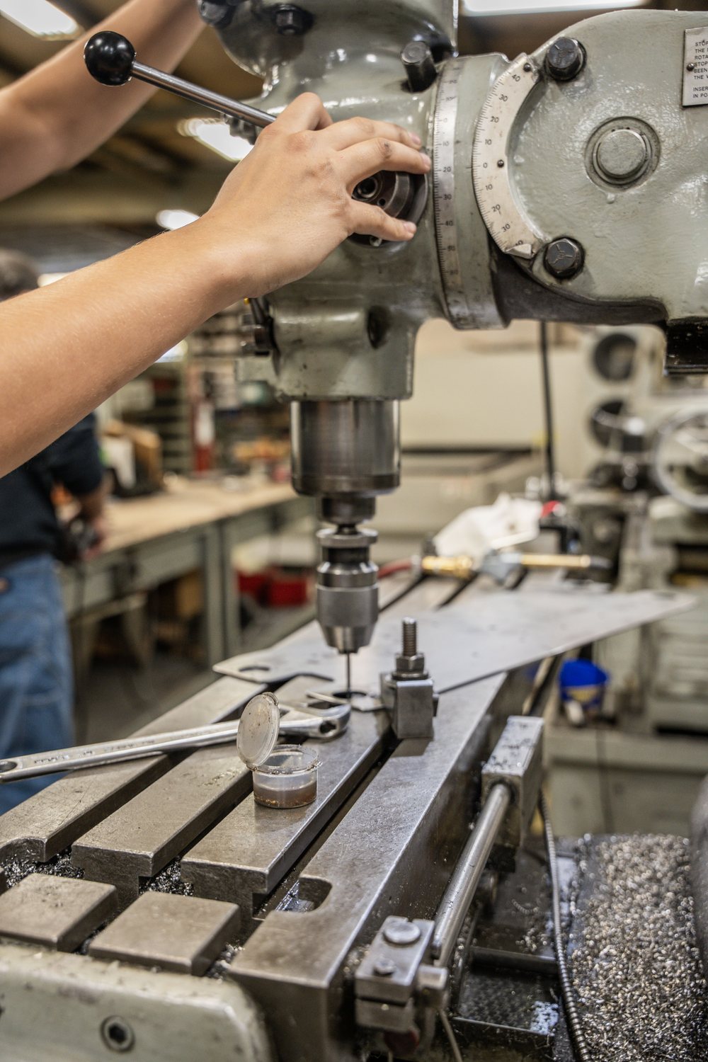 A machinist running a milling machine in the STI shop