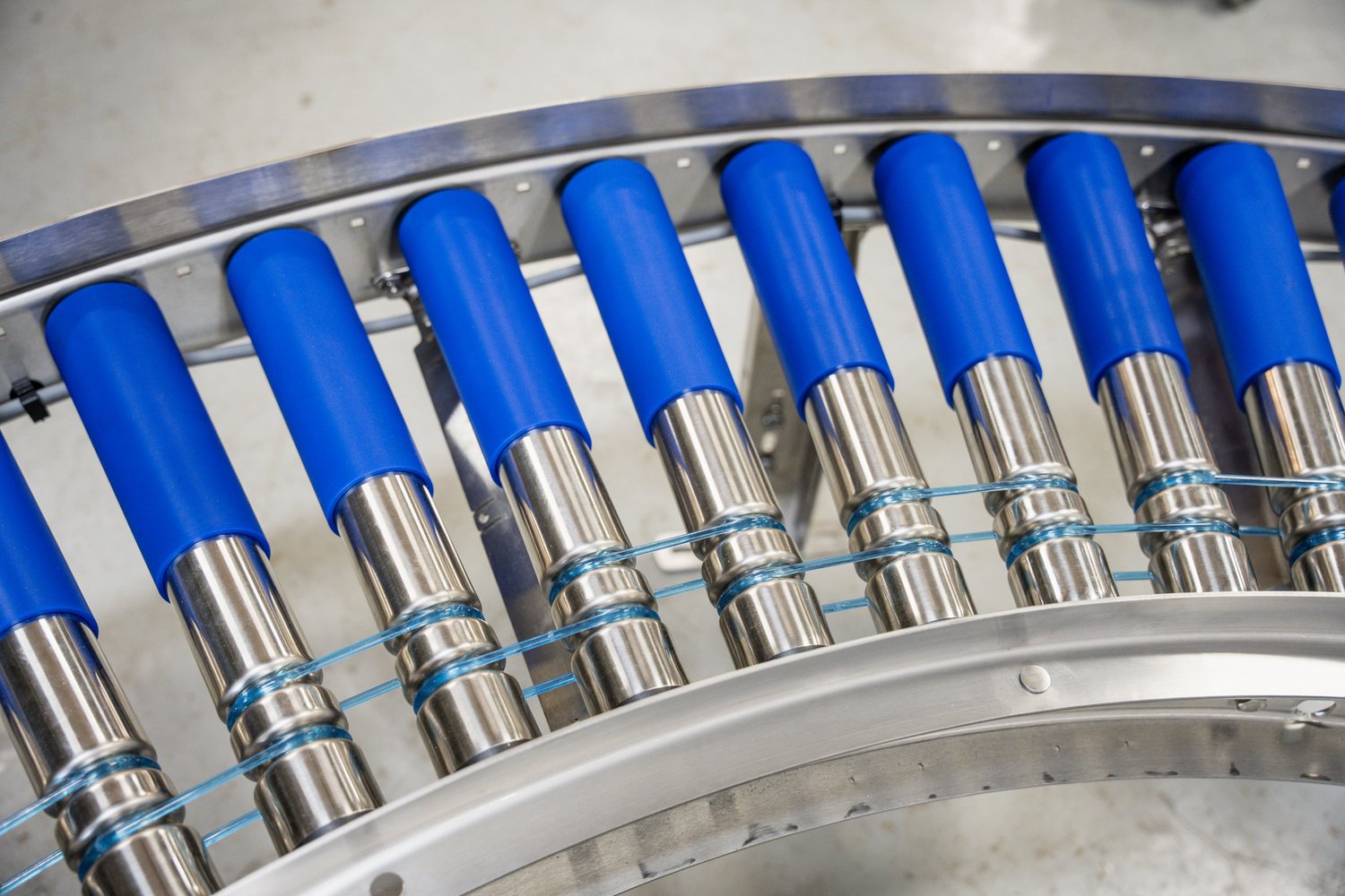Blue powered-roller conveyor sections on a curved frame