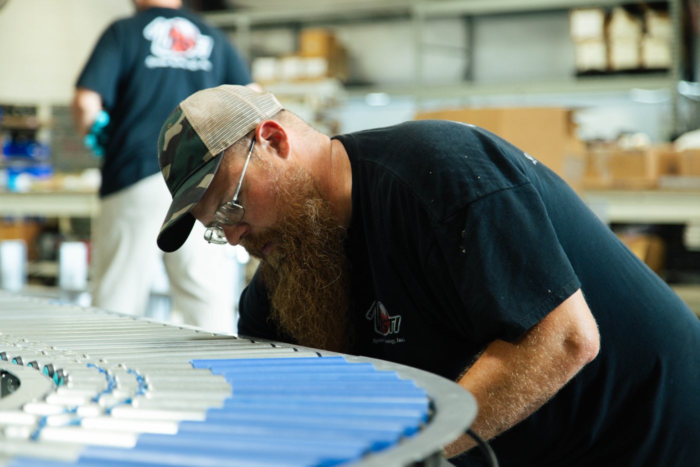 An STI builder assembling a powered-roller conveyor line
